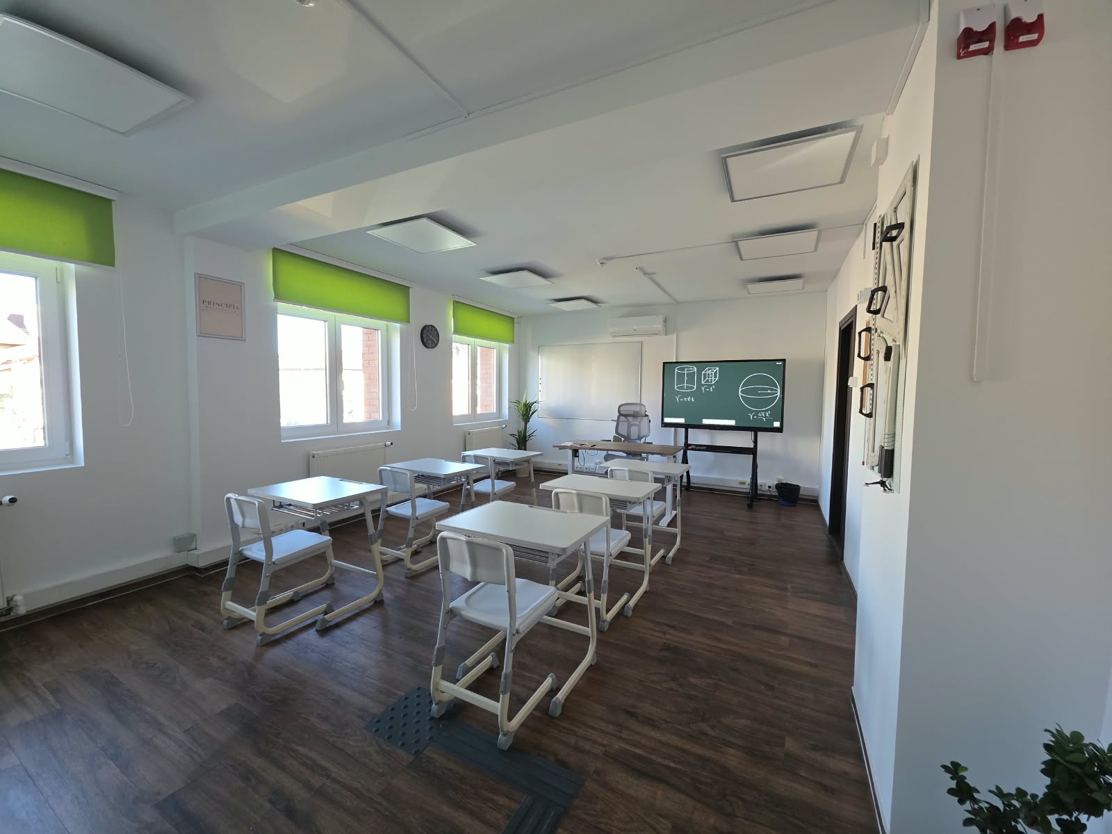 Sala de clasă Principia cu bănci pentru elevi și tablă cu figuri geometrice